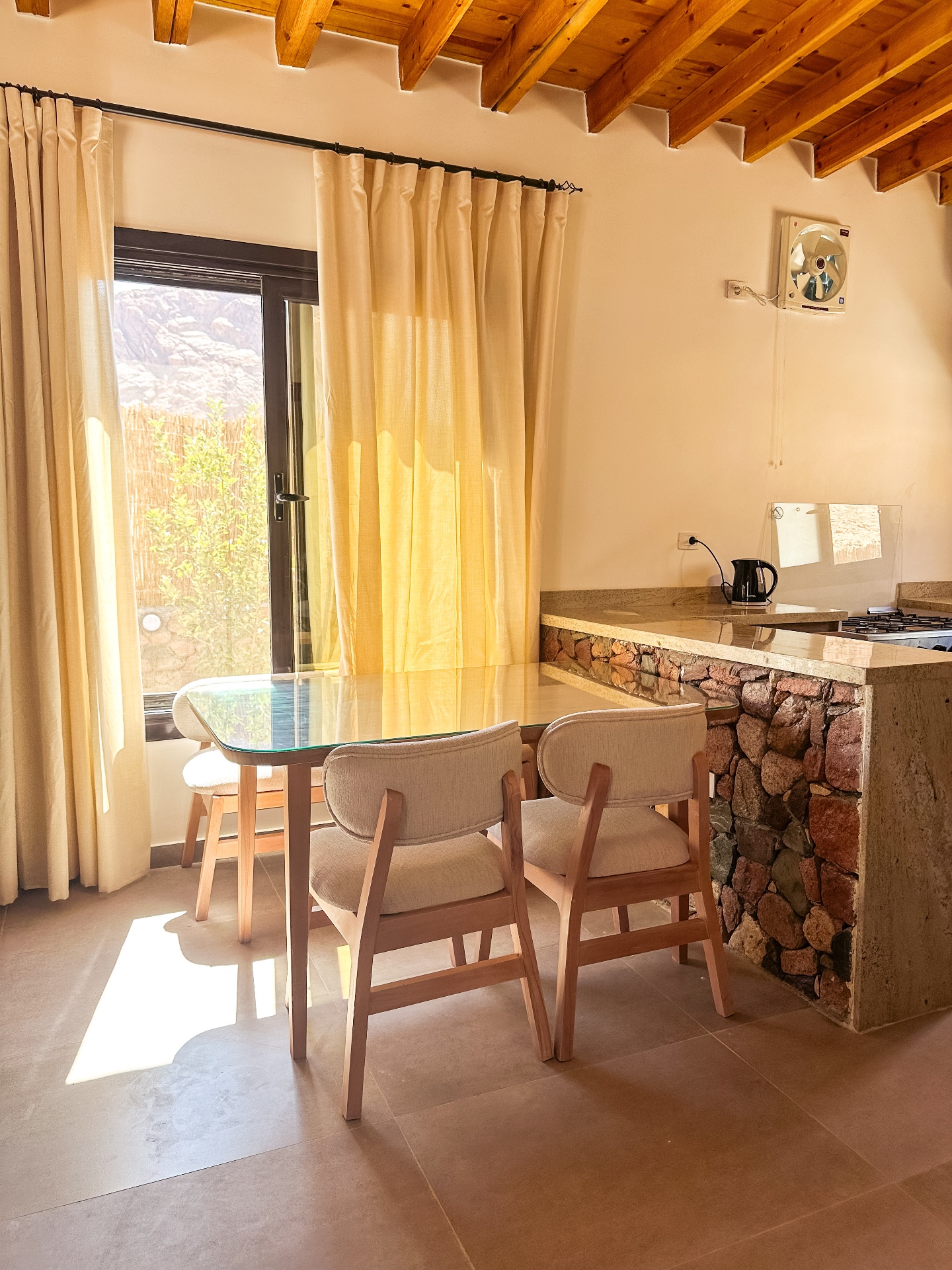 Modern kitchen and dining area with stone accents and natural lighting